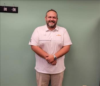 SERVPRO employee in front of gray wall