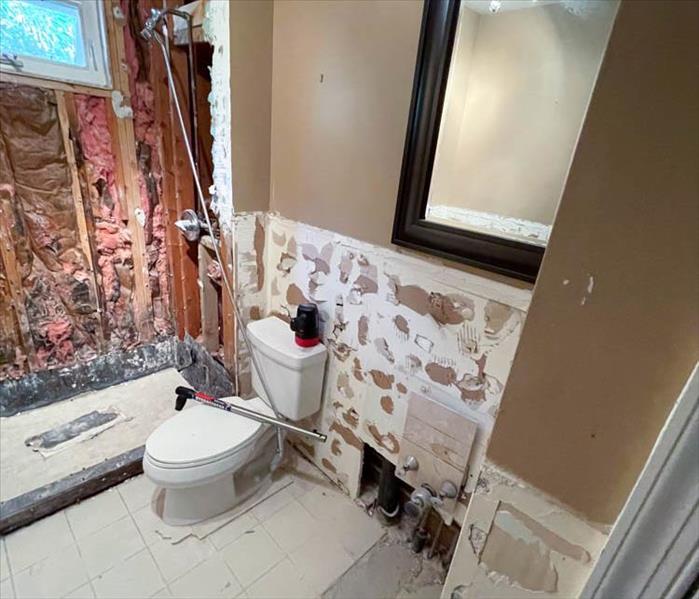 Water damaged bathroom with drywall removed